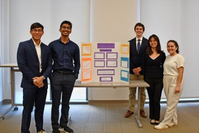 Five students stand with their posterboard created for data competition.