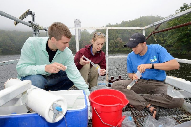 Cayelan Carey, an assistant professor of biological sciences in the College of Science (center), works with graduate students Jonathan Doubek (left) and Ryan McClure (right) to filter water samples at Falling Creek Reservoir for analysis of iron and manganese concentrations. File photo from 2017.