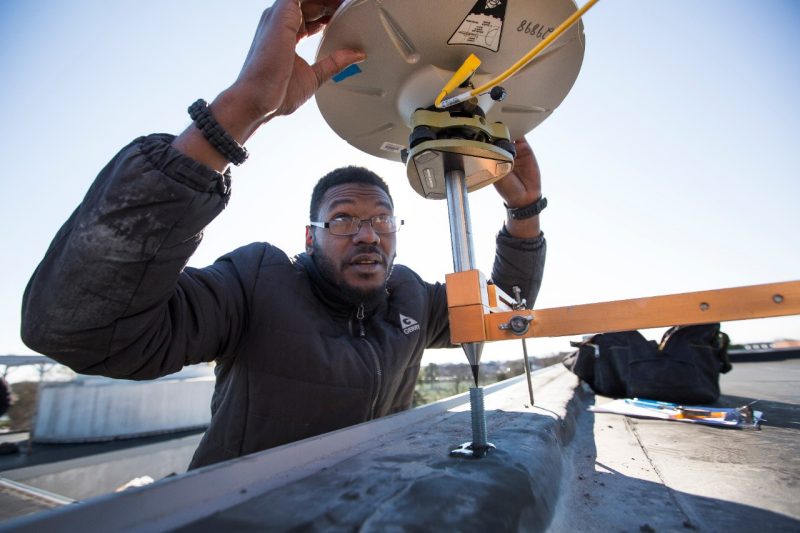 Geosciences graduate student Josh Robert Jones adjusts a GPS device
